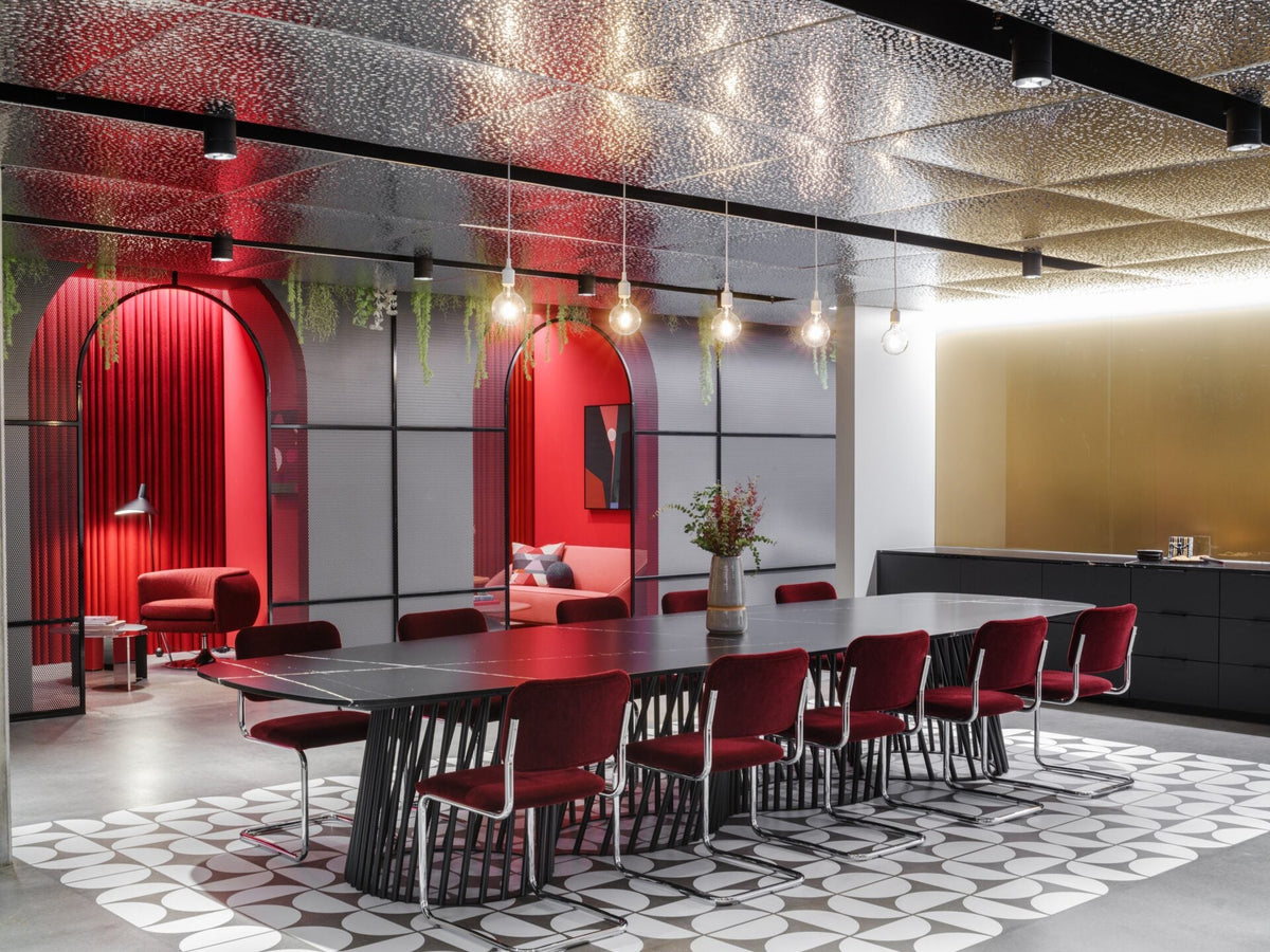 Reflective pebbled stainless steel ceiling panels in a workplace showroom