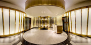 Gold-toned stainless steel entrance lobby with framed doors and a circular reception zone
