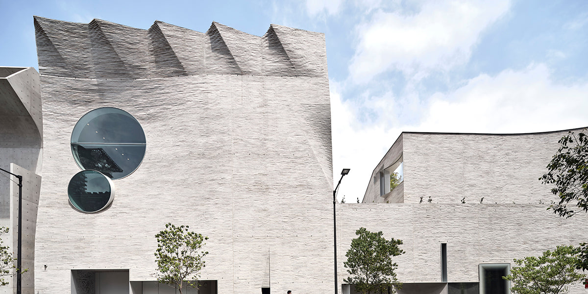 Sculptural pale brick facade with curved contours and circular openings at Phoenix Central Park Gallery