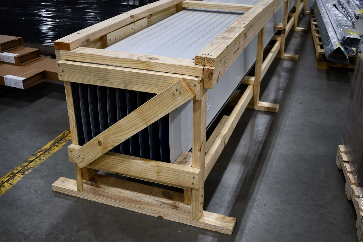 Finished metal roofing panels separated and secured inside a timber export crate