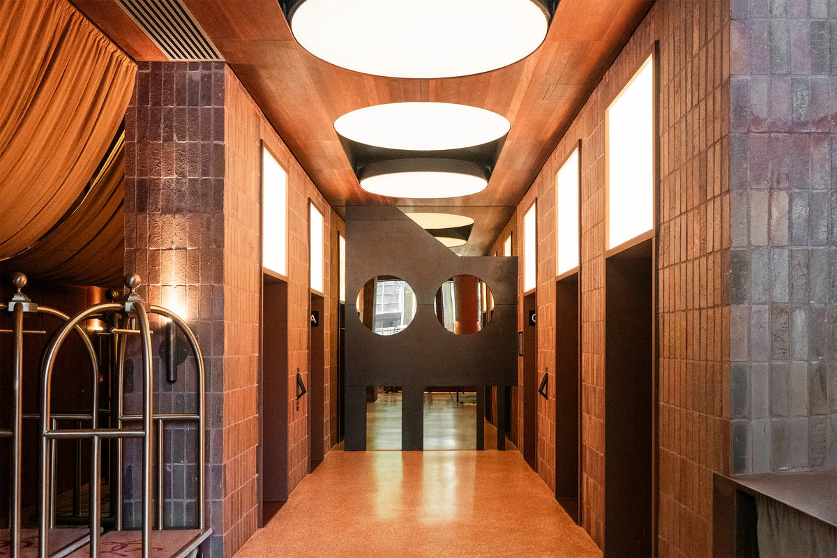Stainless steel wall cladding and warm lighting in a hotel interior