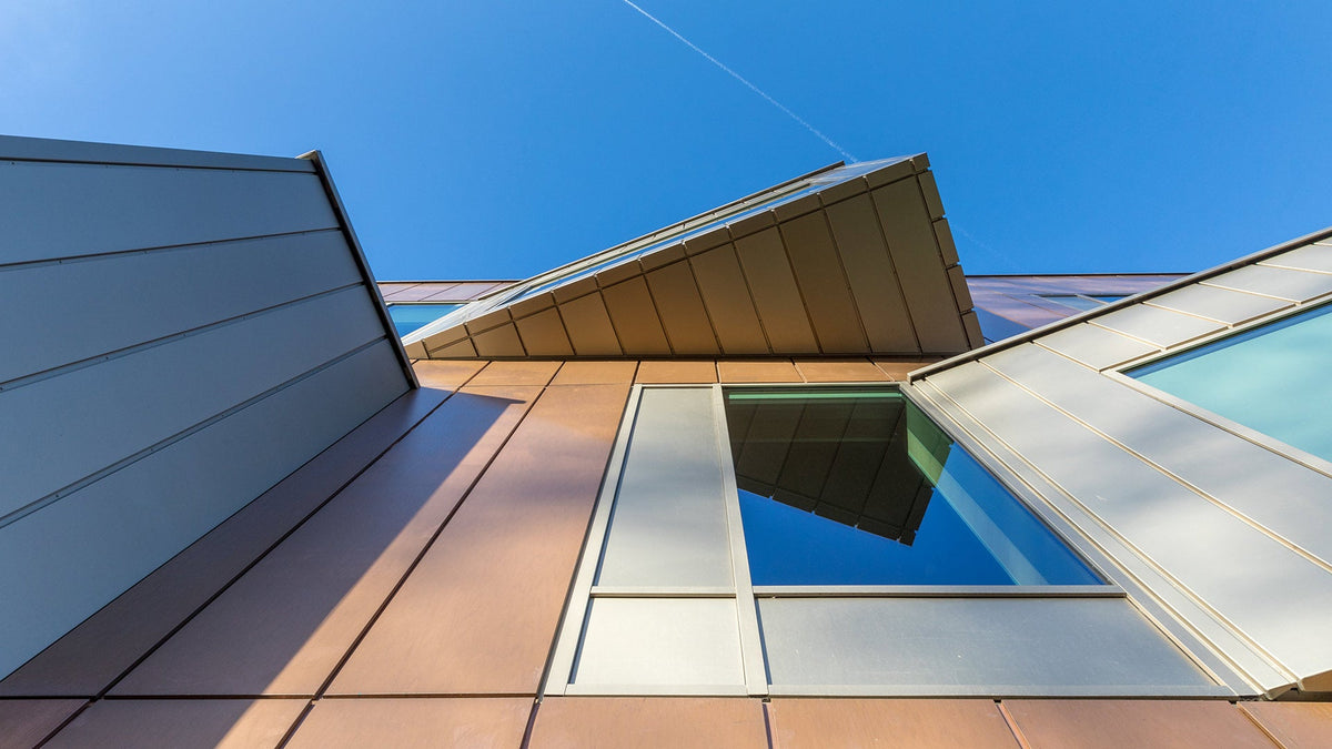 Warm reddish-brown TECU Bronze rainscreen panels on the Royal Holloway building