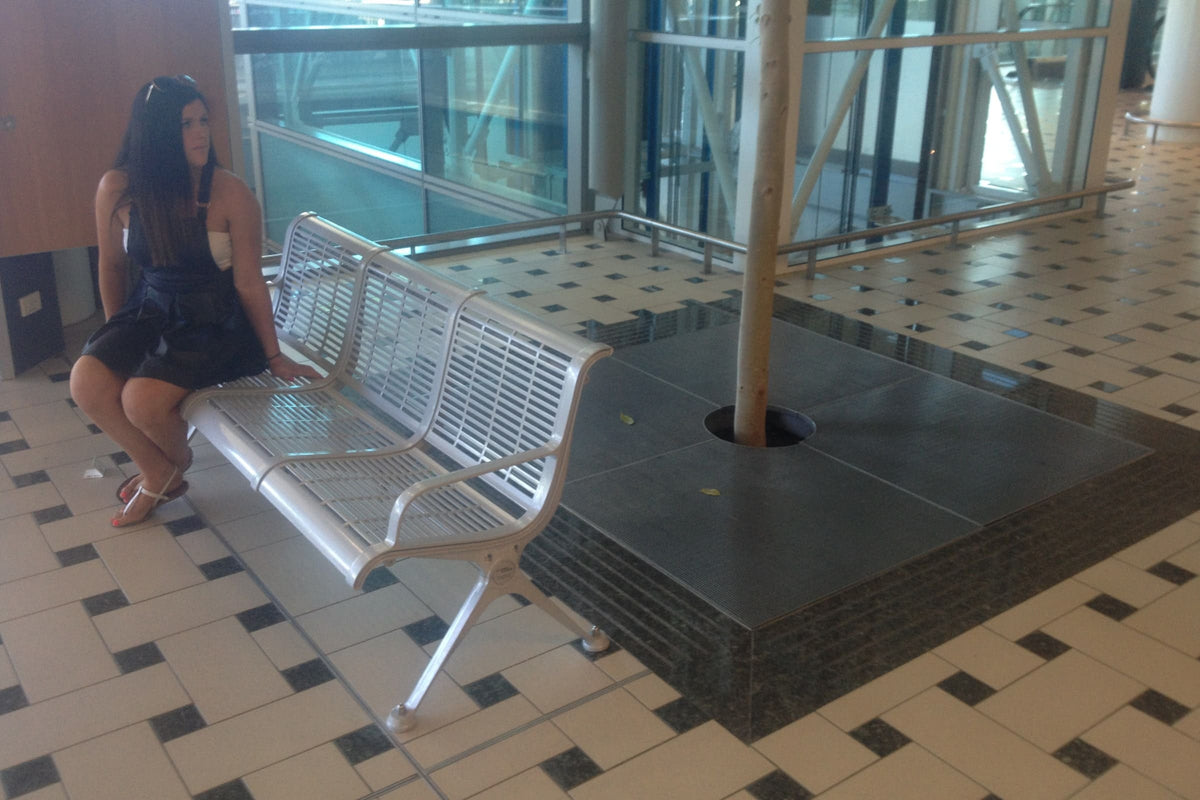 Stainless steel tree grate around an urban tree pit
