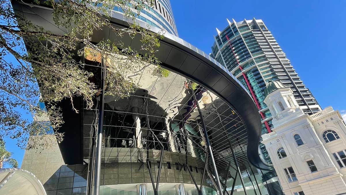 Reflective architectural soffit showing the surrounding buildings in its surface