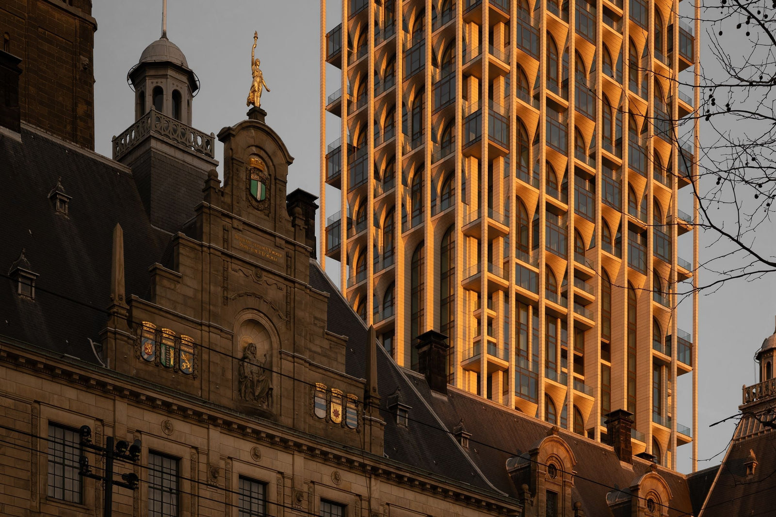 POST Rotterdam Tower rising behind the historic Postkantoor with a stone grid facade
