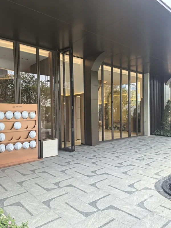 Dark gold PVD stainless steel and glass entrance with a continuous metal canopy