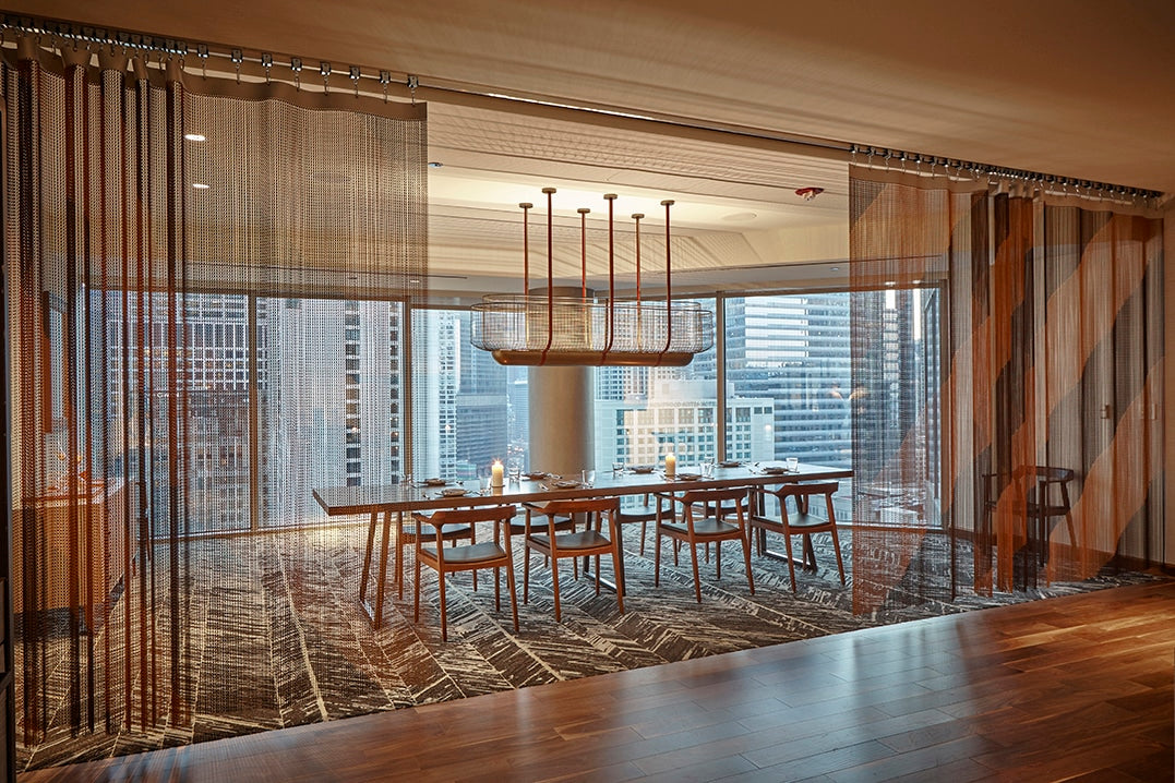 Movable bronze-and-black chain divider in the private dining area at Conrad Chicago