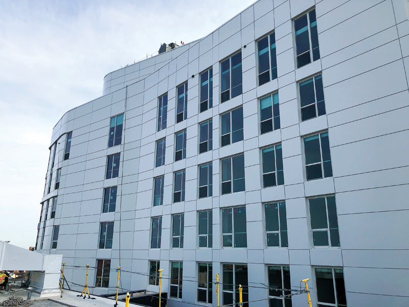 Under-construction multi-storey building with installed MCM rainscreen panels