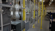 Metal access-panel frames moving through a finishing line