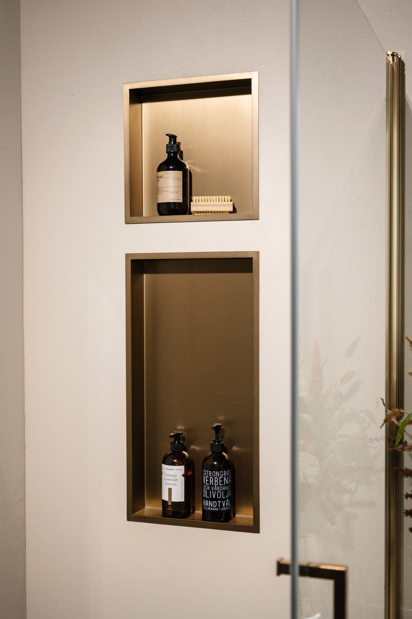 Custom stainless steel shower wall niche with bronze-toned finish