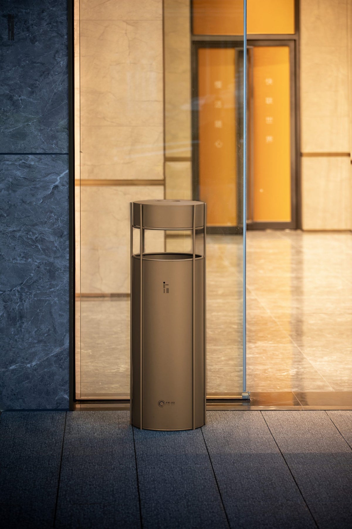 Architectural stainless steel hotel waste receptacle with bronze-toned finish