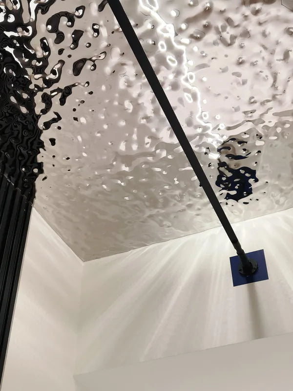 Close view of rippled reflective ceiling and suspended linear fixture