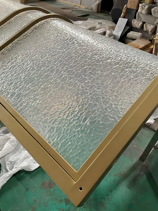 Surface and edge detail of curved bronze textured glass stainless steel screen