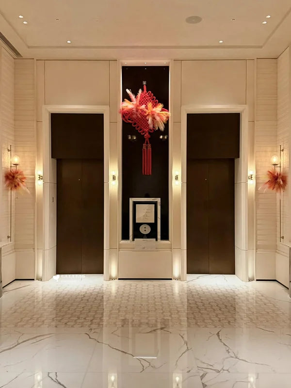 Two hotel elevator doors in light stone-look wall for custom Xinmao Metal elevator design