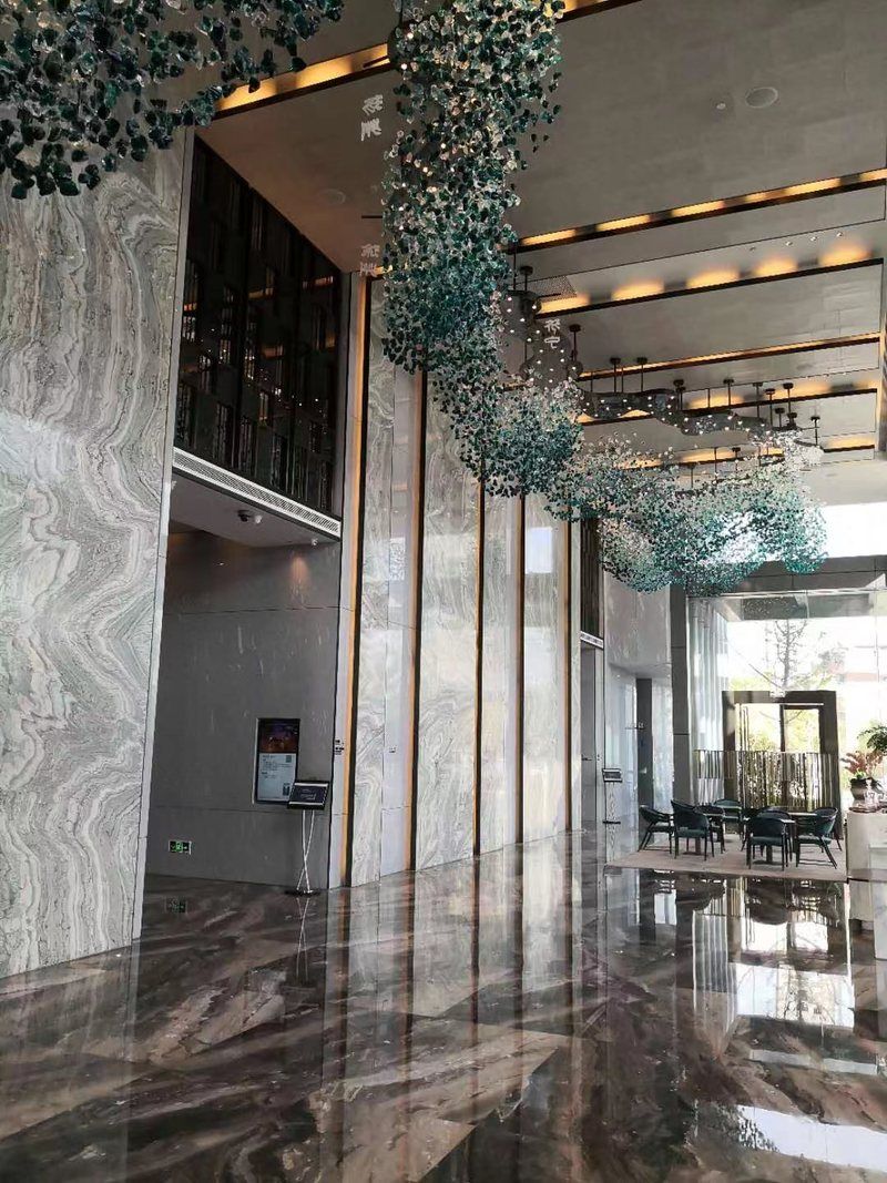 Repeated stainless steel screen panels and decorative lights line the Hilton hotel corridor entrance.