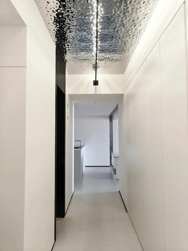 Long hallway view of water ripple ceiling strip and centered linear light