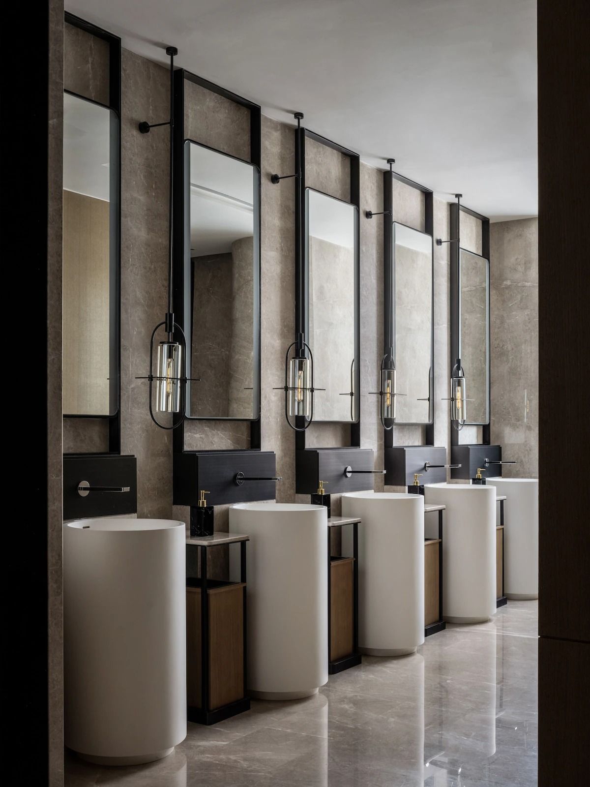 Commercial vanity mirror cabinets with dark frames at a multi-station washroom