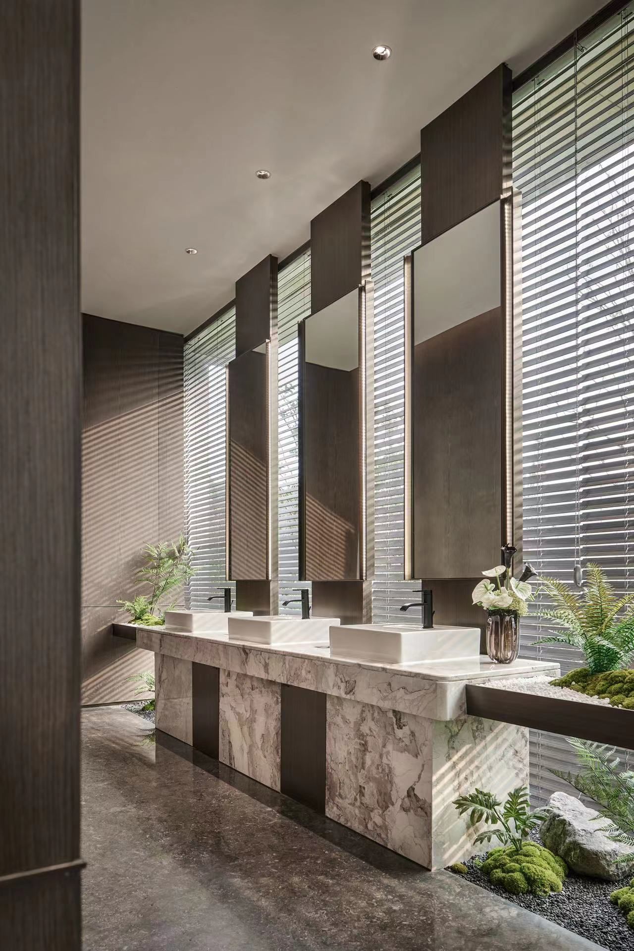Tall bronze toned mirror cabinets in a commercial washroom