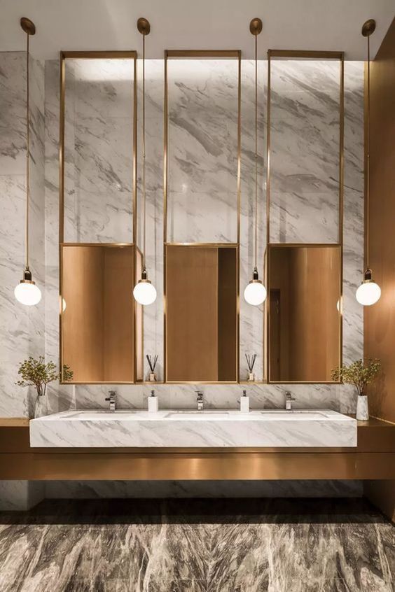 Gold framed commercial mirror cabinet array above washbasins