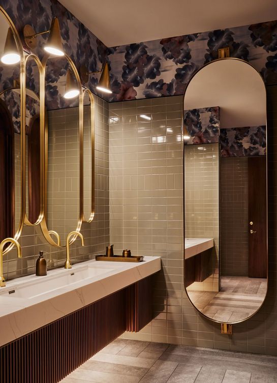Arched bronze mirror cabinets at a multi-station washroom