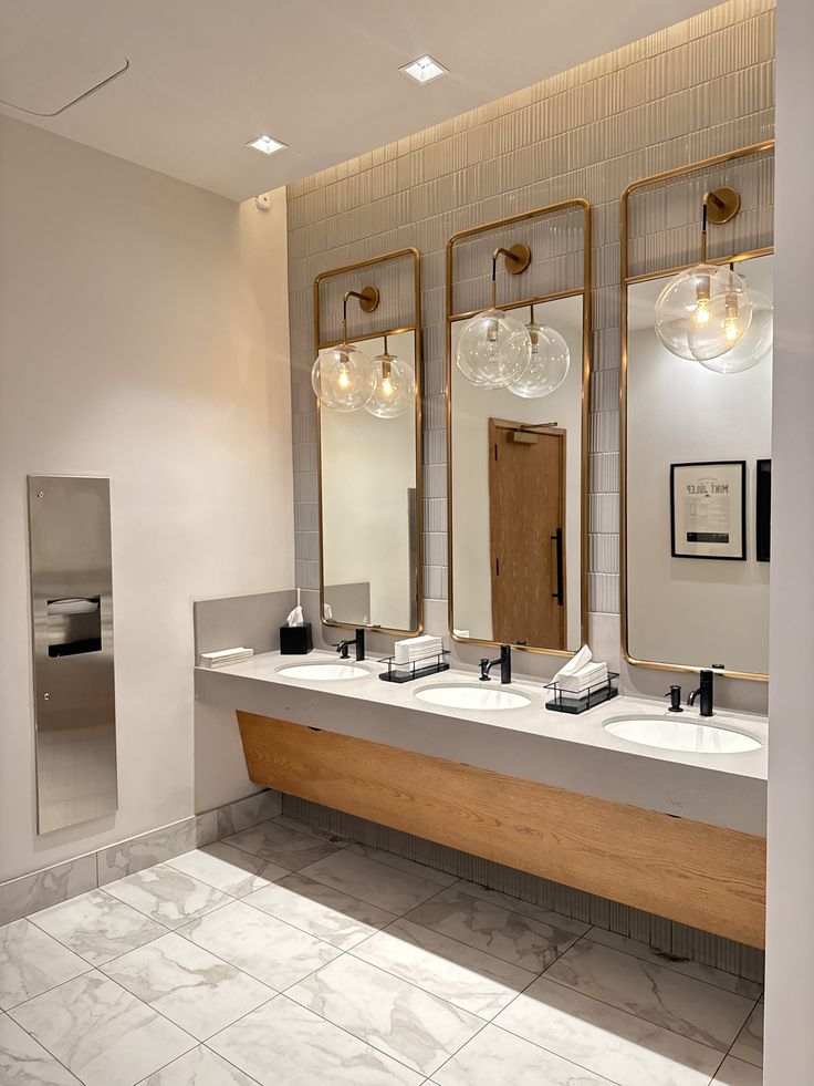 Gold framed mirror cabinets over commercial washbasins