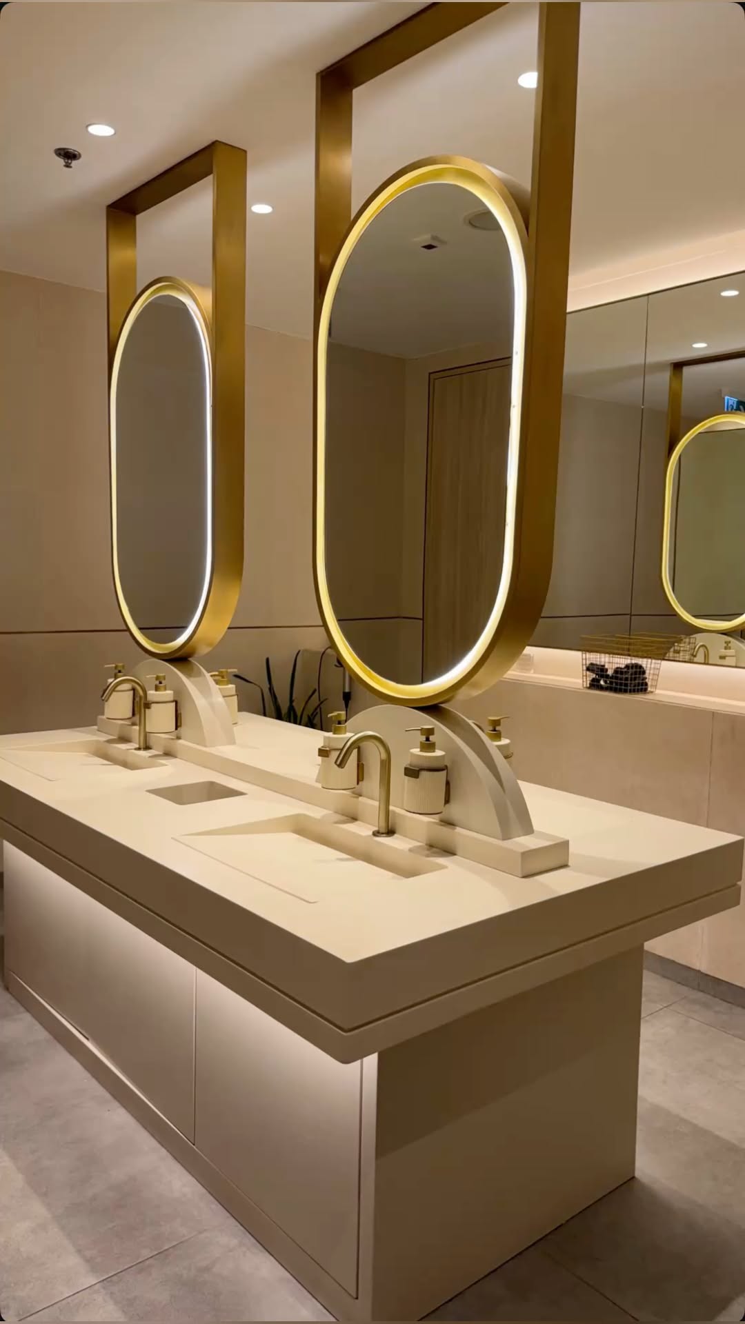 Circular gold framed mirror cabinet feature at a vanity