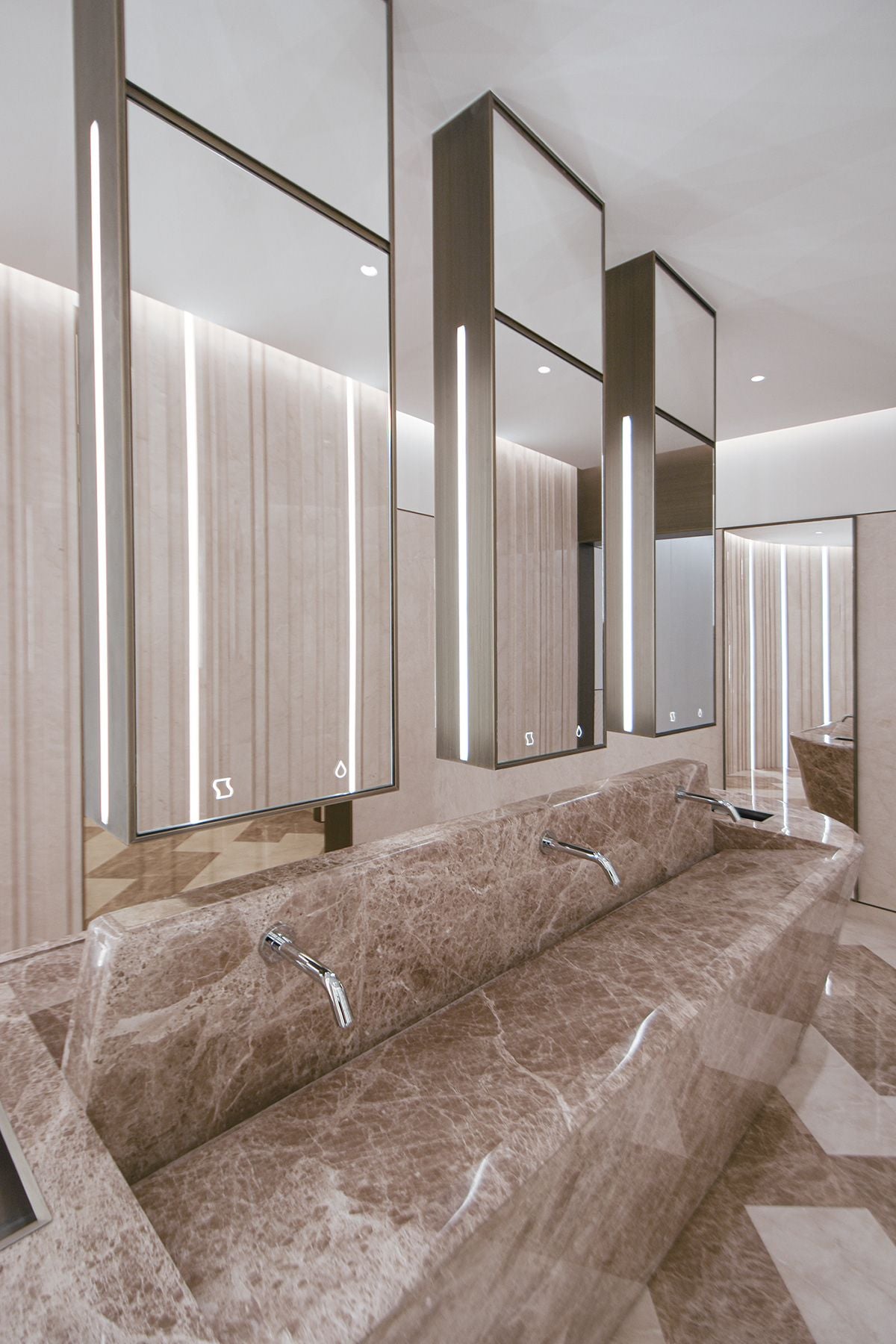 Tall illuminated mirror cabinets at a commercial wash counter