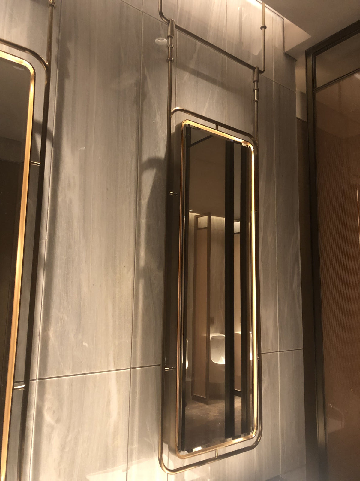 Bronze edged illuminated mirror cabinet in a dark interior