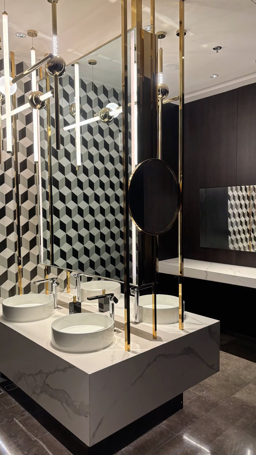 Gold framed mirror cabinet structure at twin washbasins