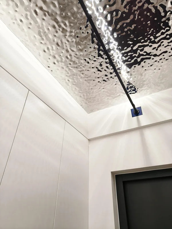 Reflective corridor ceiling with linear lamp and white wall corner