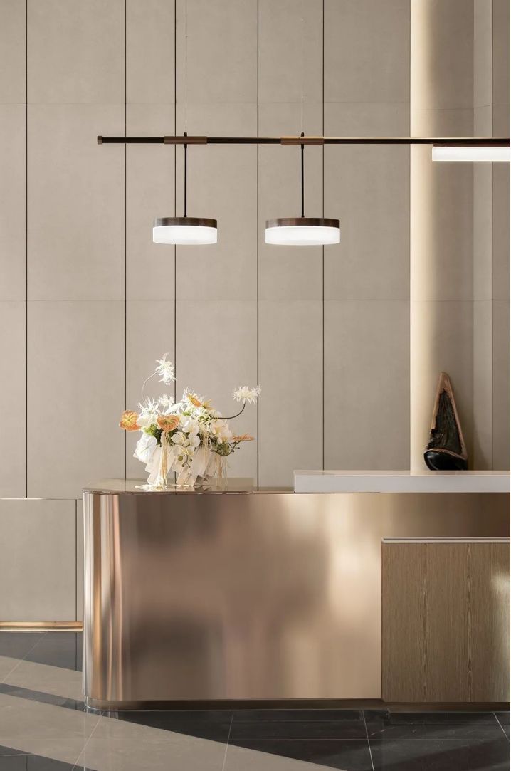 Curved bronze-tone stainless steel reception desk for hotel, clinic and executive office lobbies