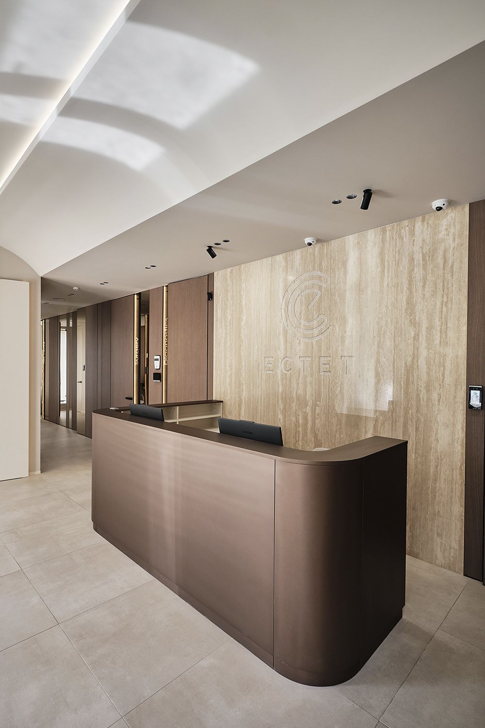 Curved bronze-tone stainless steel reception desk for hotel, clinic and executive office lobbies