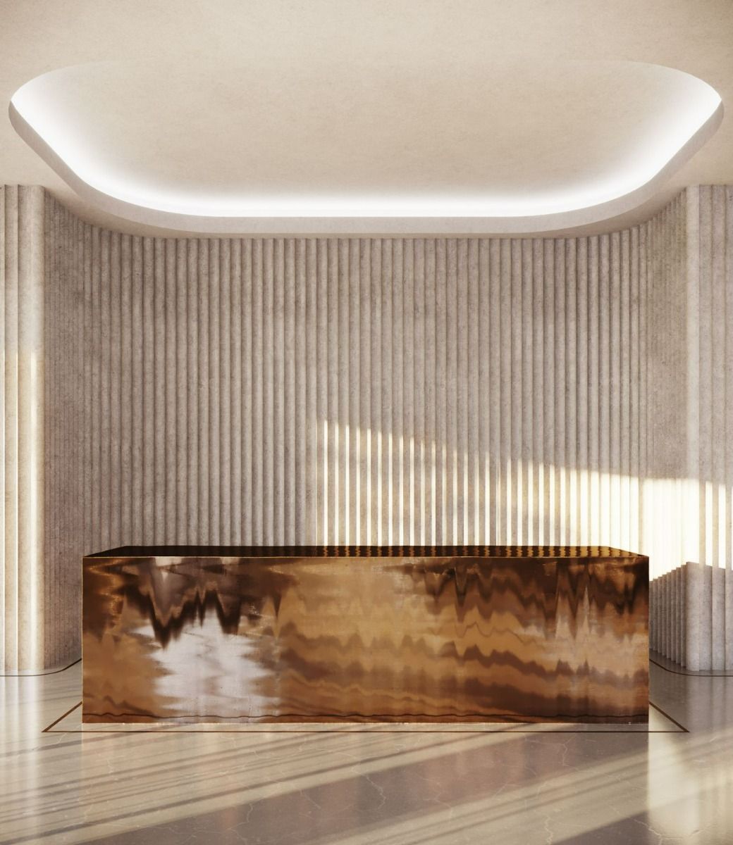Sculptural folded bronze-finish stainless steel reception desk for premium commercial interiors