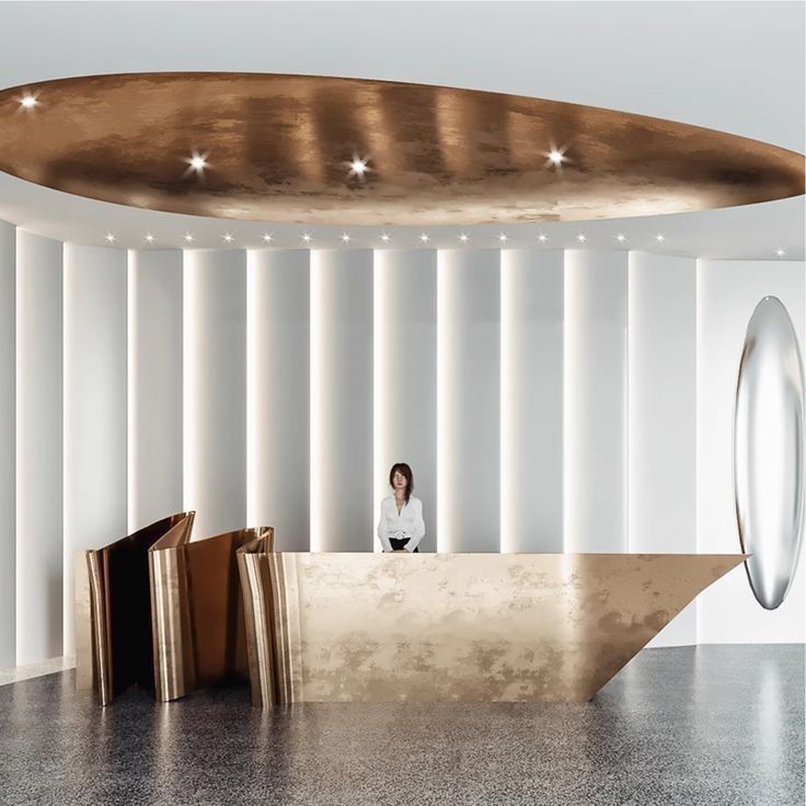 Sculptural folded bronze-finish stainless steel reception desk for premium commercial interiors