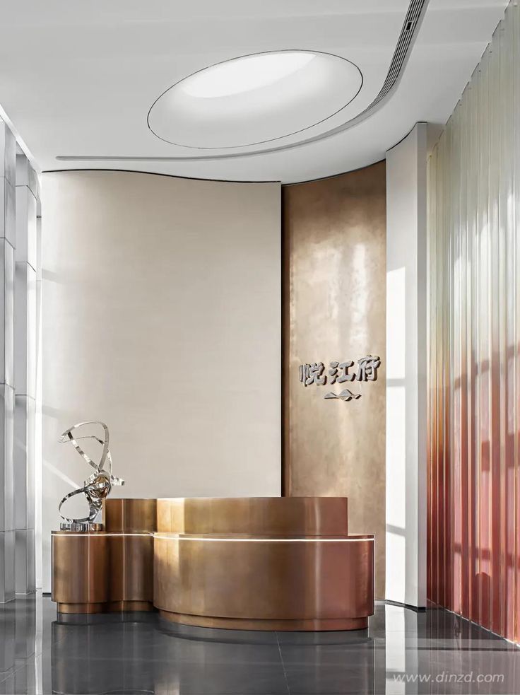Sculptural folded bronze-finish stainless steel reception desk for premium commercial interiors