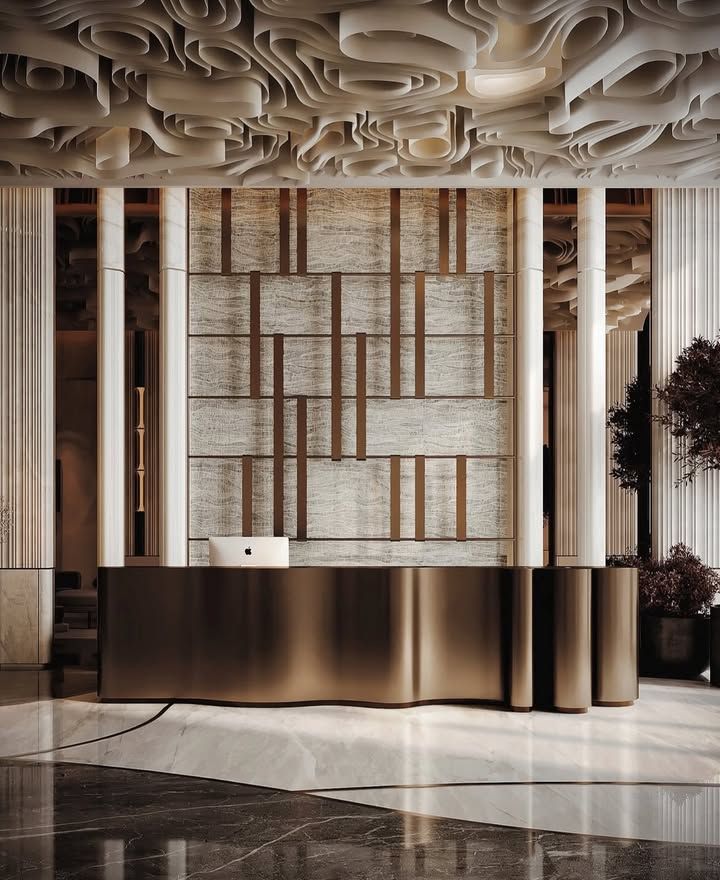 Sculptural folded bronze-finish stainless steel reception desk for premium commercial interiors