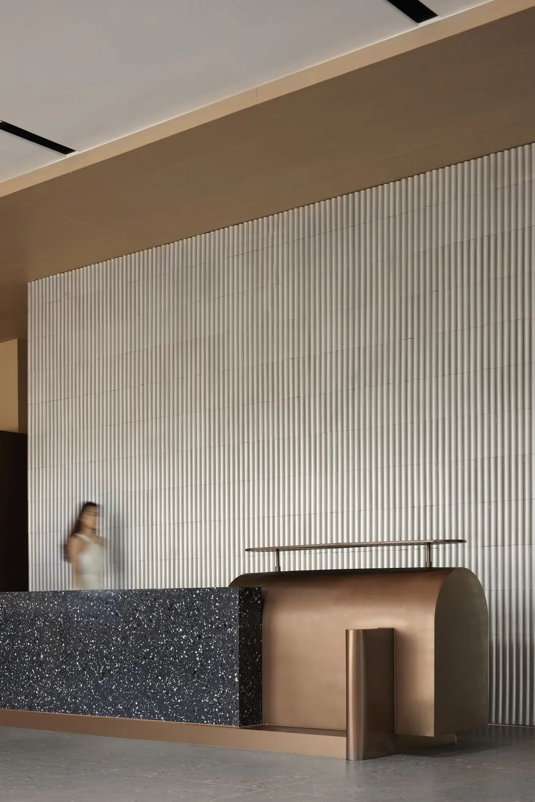 Linear warm-bronze stainless steel hotel reception desk for multi-position check-in areas