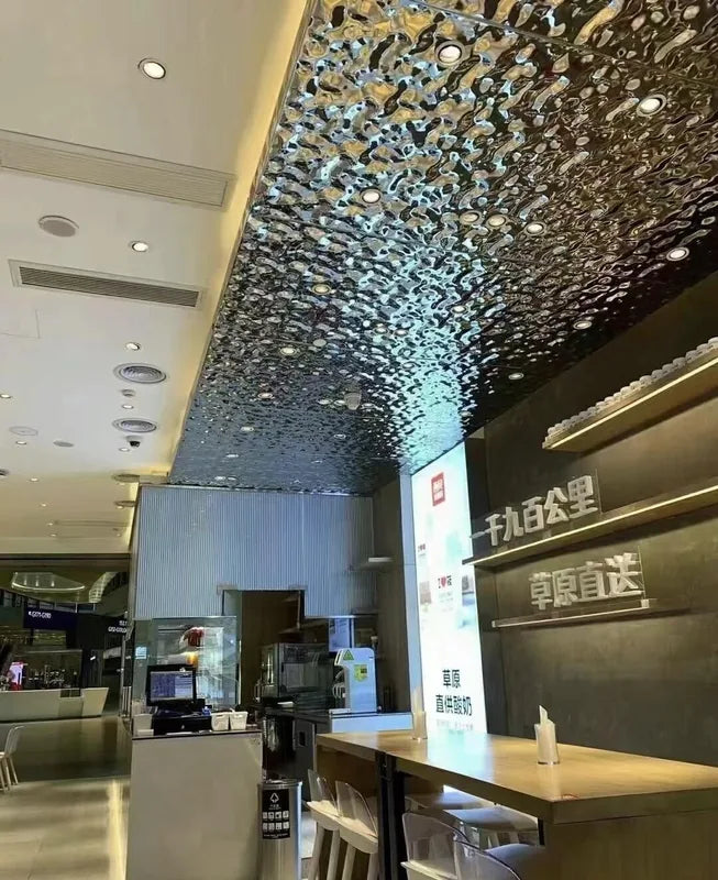 Water ripple metal ceiling feature over commercial counter