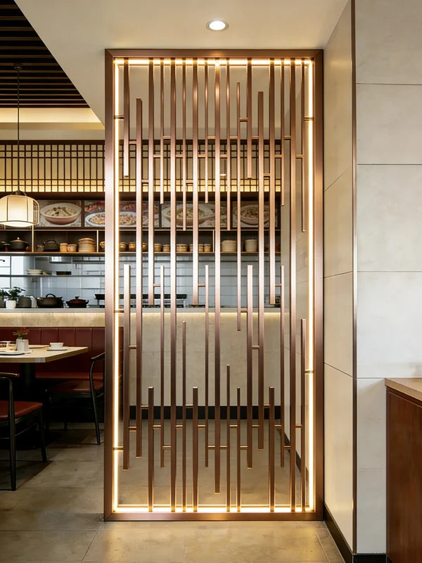 Gold-toned stainless steel grille screen dividing a restaurant entrance