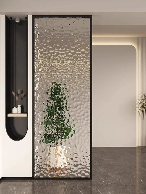 Black-framed stainless steel screen with textured translucent infill at an entry