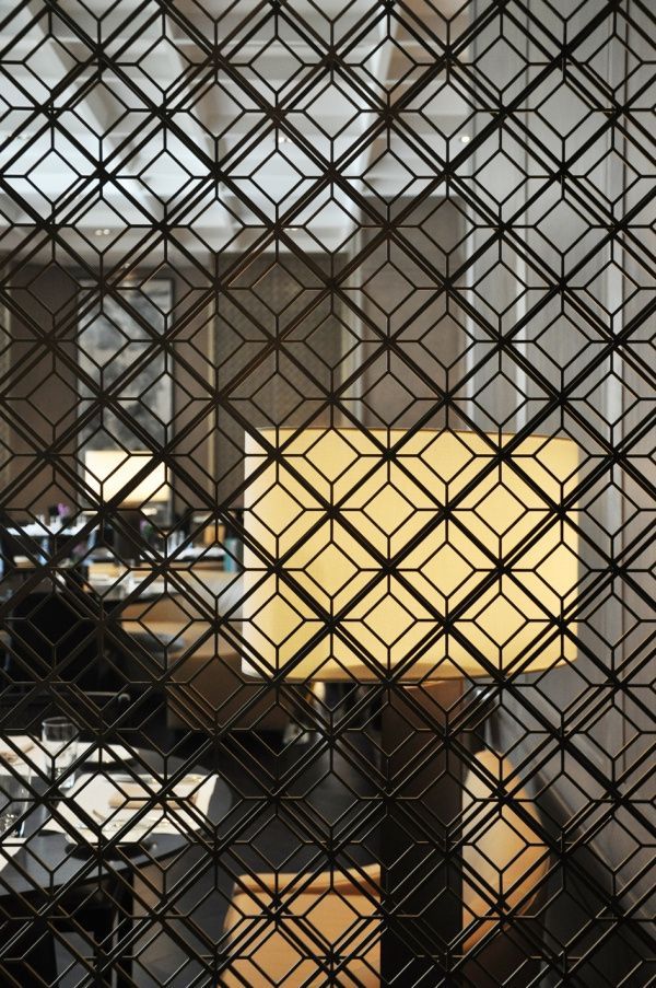 Black stainless steel screen panel with a repeating diamond lattice pattern in close view.