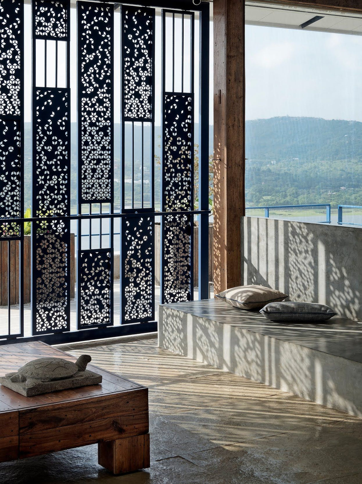 Black stainless steel screen panels with geometric cut-outs and vertical sections on a terrace.