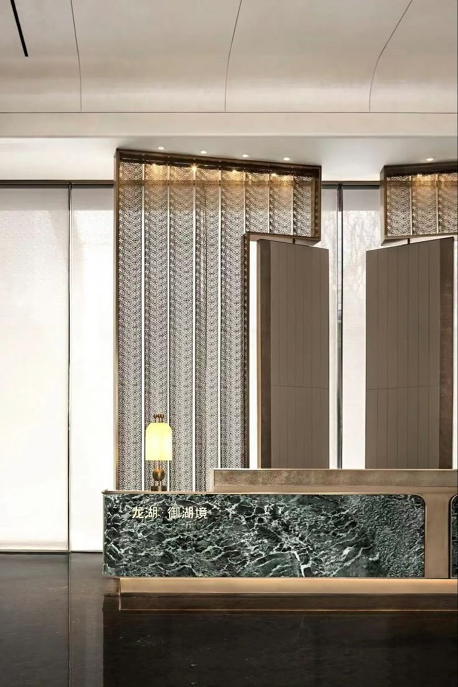 Framed decorative stainless steel screen panels with a small geometric mesh pattern behind a reception desk.