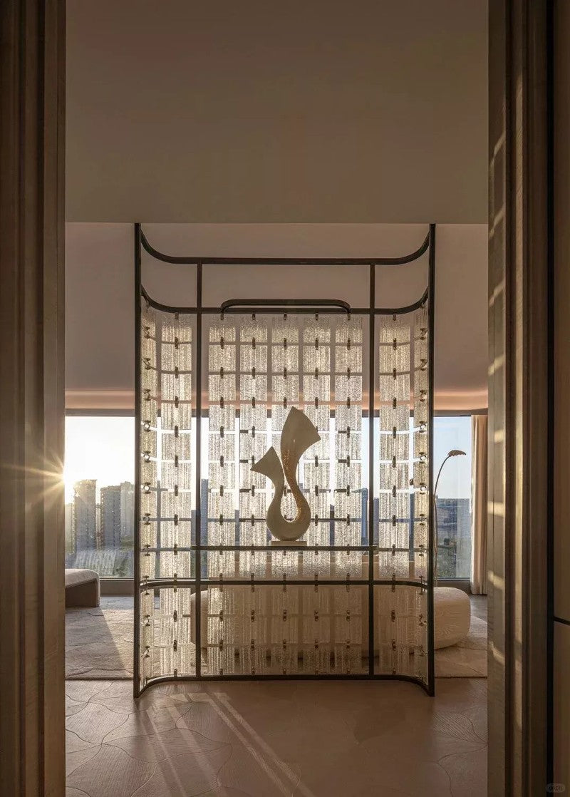 Bronze-toned stainless steel screen with textured translucent panels forming a room divider.