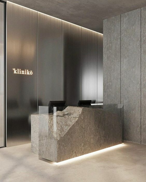 Dark smooth stainless steel wall panels behind a clinic reception desk.