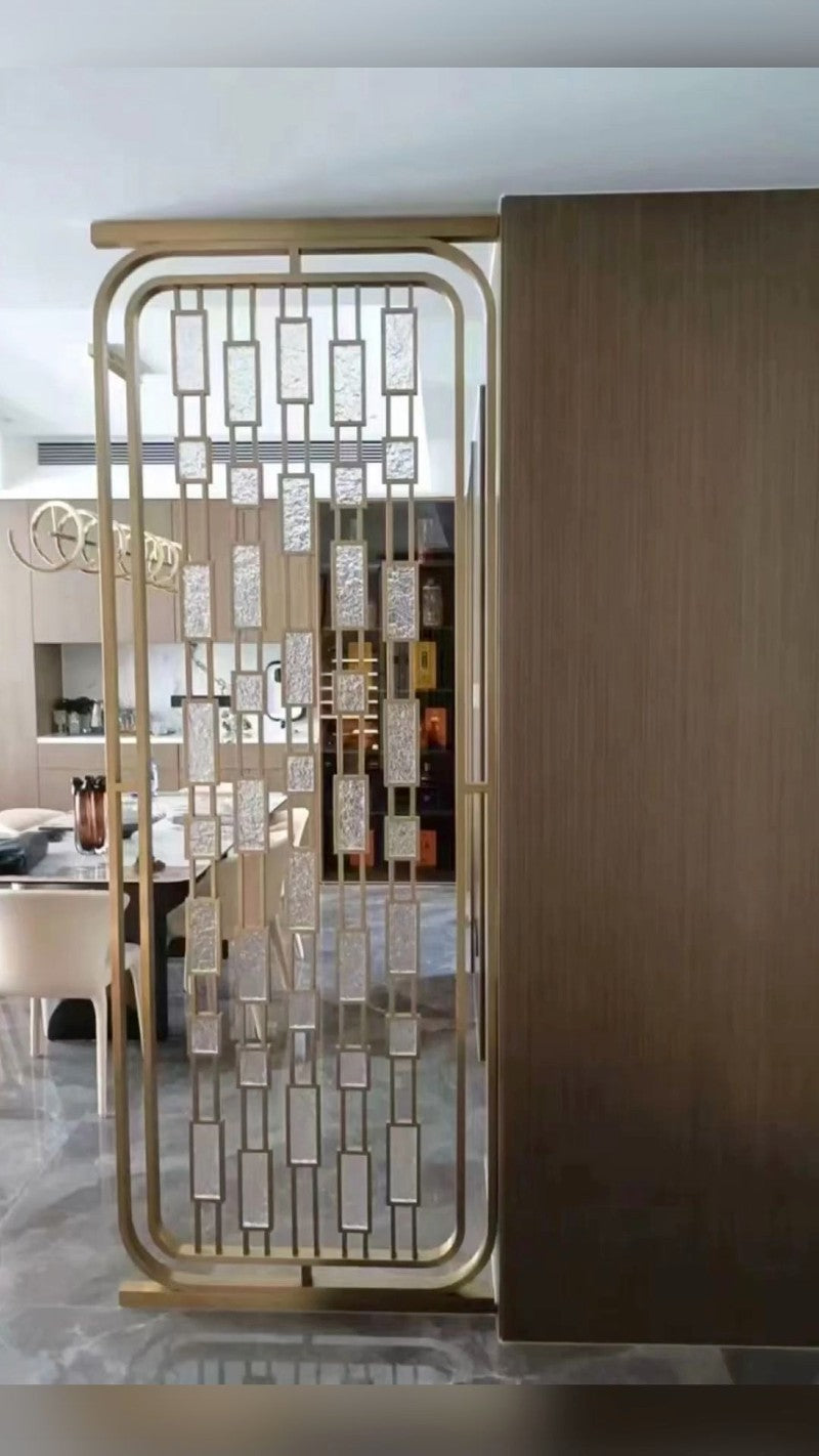 Gold-toned stainless steel framed screen with suspended rectangular translucent panels in a home interior.