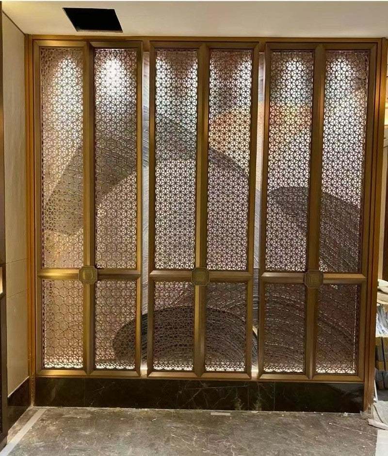Gold-toned stainless steel framed screen with a dense geometric lattice pattern in an interior wall.