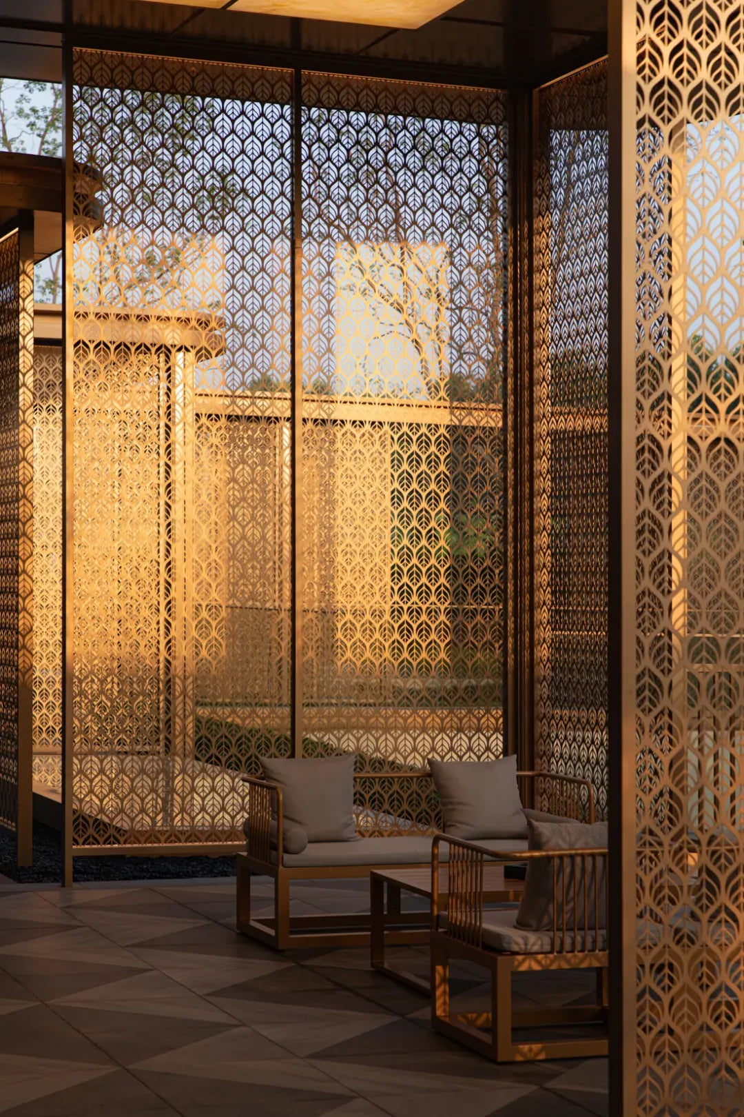 Gold-toned stainless steel screen panels with a repeating leaf pattern around an outdoor seating area.