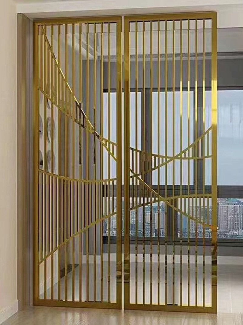 Gold-toned stainless steel screen with vertical bars and curved bands dividing an interior space.