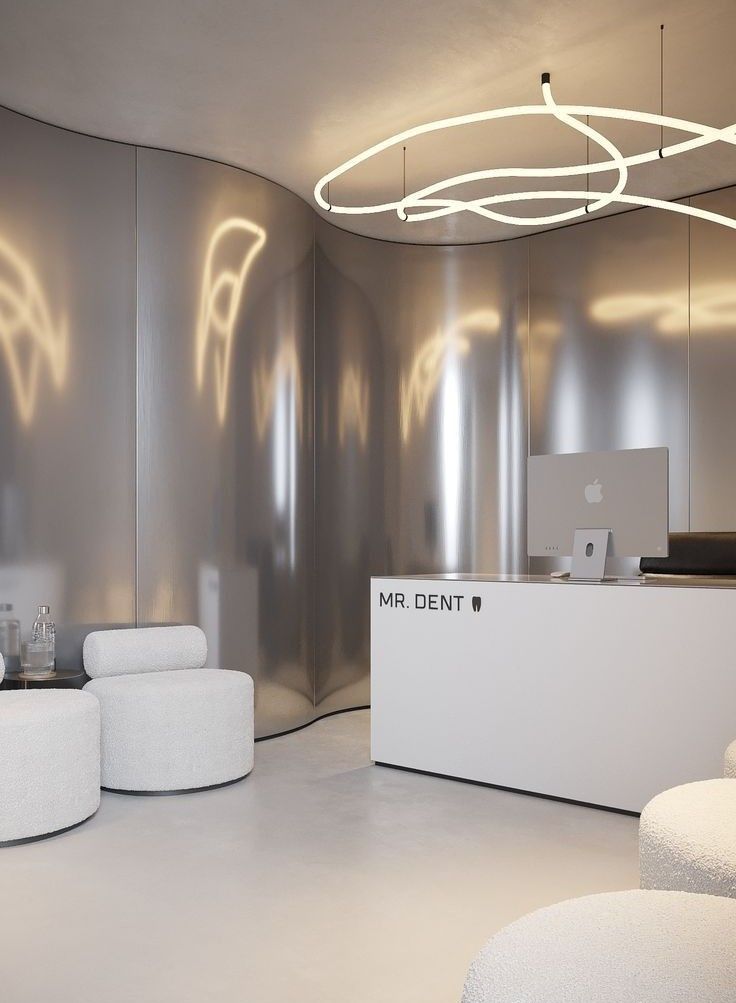 Silver stainless steel wall panels wrapping a curved clinic reception area.